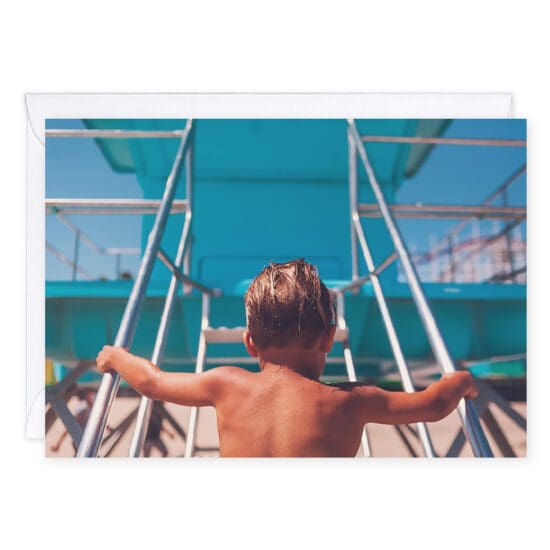 Beach more worry less greeting card shows a little blond-haired boy climbing a lifeguard tower at the Santa Cruz Beach Boardwalk. His suntanned back is to us, and he's on his way up the stairs. The Giant Dipper is in the background.