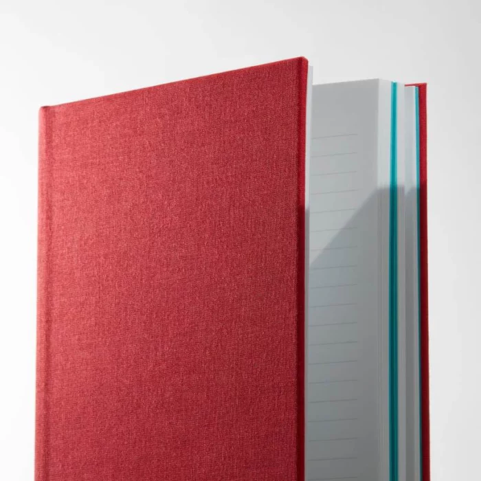 Berry Red Hardcover Notebook. Lined. Side shot of the cloth berry red notebook, showing lined pages.