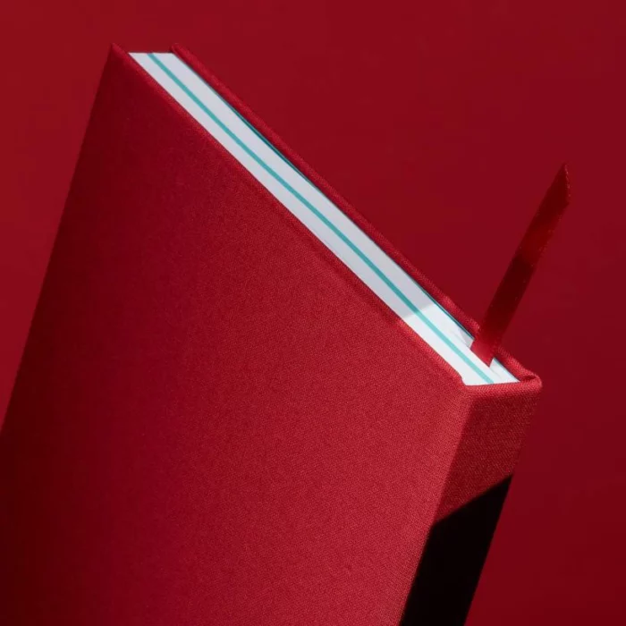Berry Red Hardcover Notebook. Ribbon. Side shot of the berry red notebook, with the placeholder ribbon in berry red.