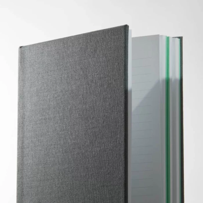 Charcoal Grey Hardcover Notebook. Side shot of the cloth charcoal grey notebook, showing lined pages.
