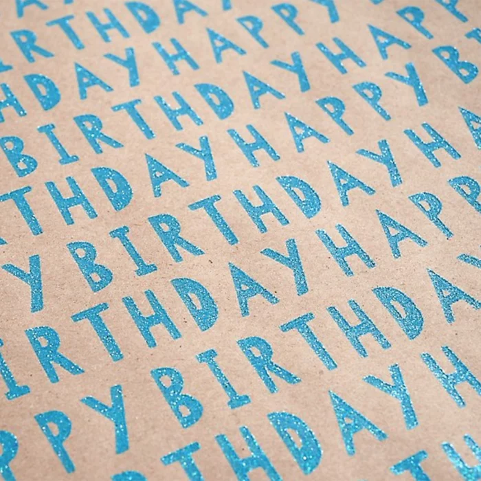 Happy Birthday Wrapping Paper. The paper bag background compliments the blue glitter text. Match this wrapping paper with a birthday card and gift ribbons. 27.5″ x 57″ continuous roll.