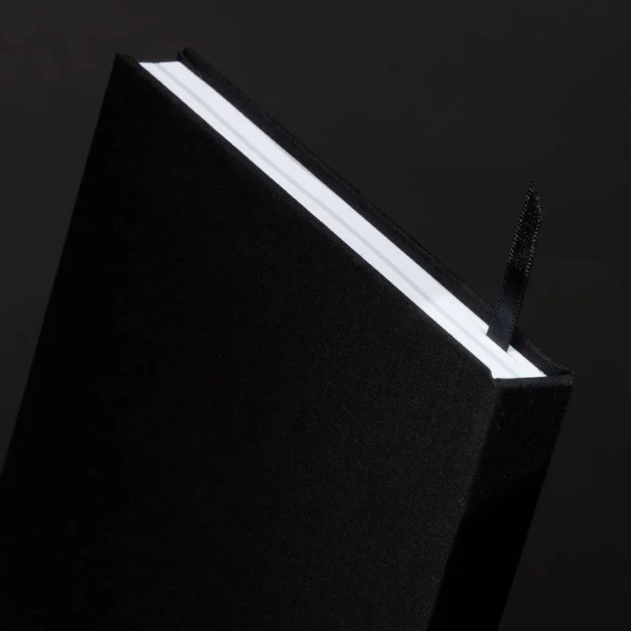 Jet Black Hardcover Notebook. Ribbon. Side shot of the jet black notebook, with the placeholder ribbon in jet black.