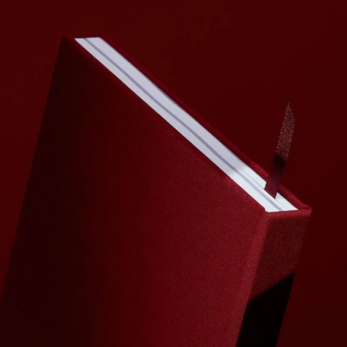 Wine Red Hardcover Notebook. Ribbon. Side shot of the wine red notebook, with the placeholder ribbon in wine red.